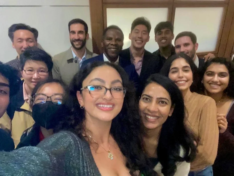 Ajijola Lab members smiling indoors, with one person holding the camera in the front.