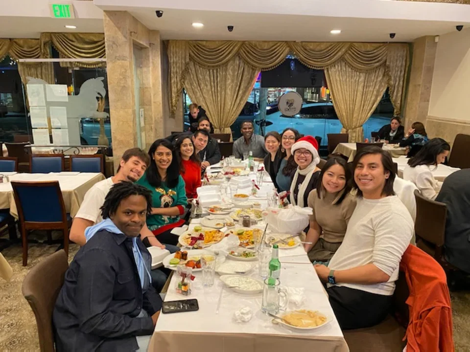 Ajijola Lab members gathered around a table for the end of year celebration.