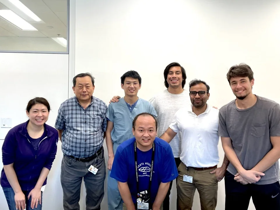 Ajijola Lab members smiling and posing indoors against a plain white wall.